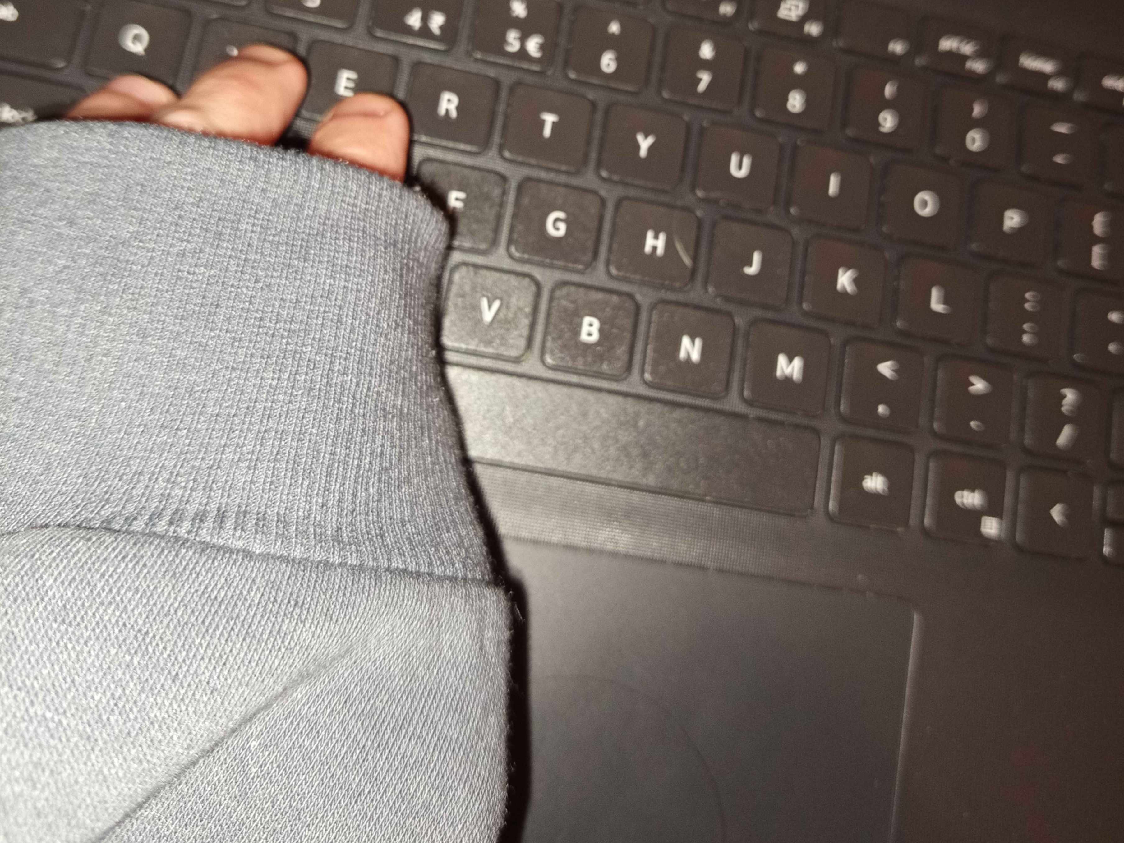 photo shows a hand almost entirely covered with a sleeve, resting over a keyboard