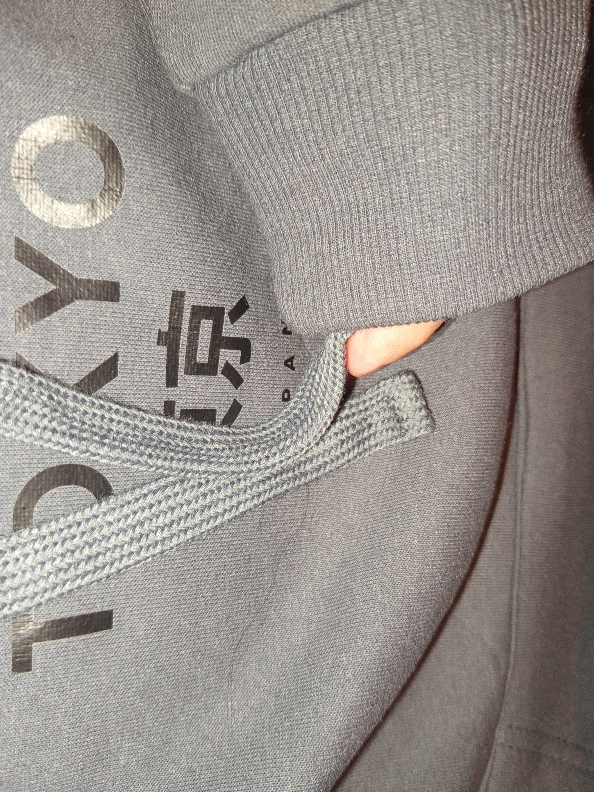 a photo shows a hoodie sleeve holding a hoodie string